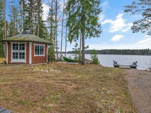 A cabin with a small deck and a dock extending into a lake, surrounded by trees. - Louhuranta by Interhome (Karstula)