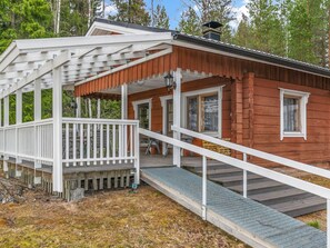 A wooden cabin with a covered porch and a ramp leading to the entrance. - Louhuranta by Interhome (Karstula)