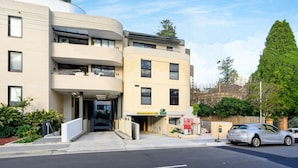 A modern building with a curved facade, a visible entrance, and a sign indicating maximum height. - THE PARK OASIS BURWOOD (Burwood)