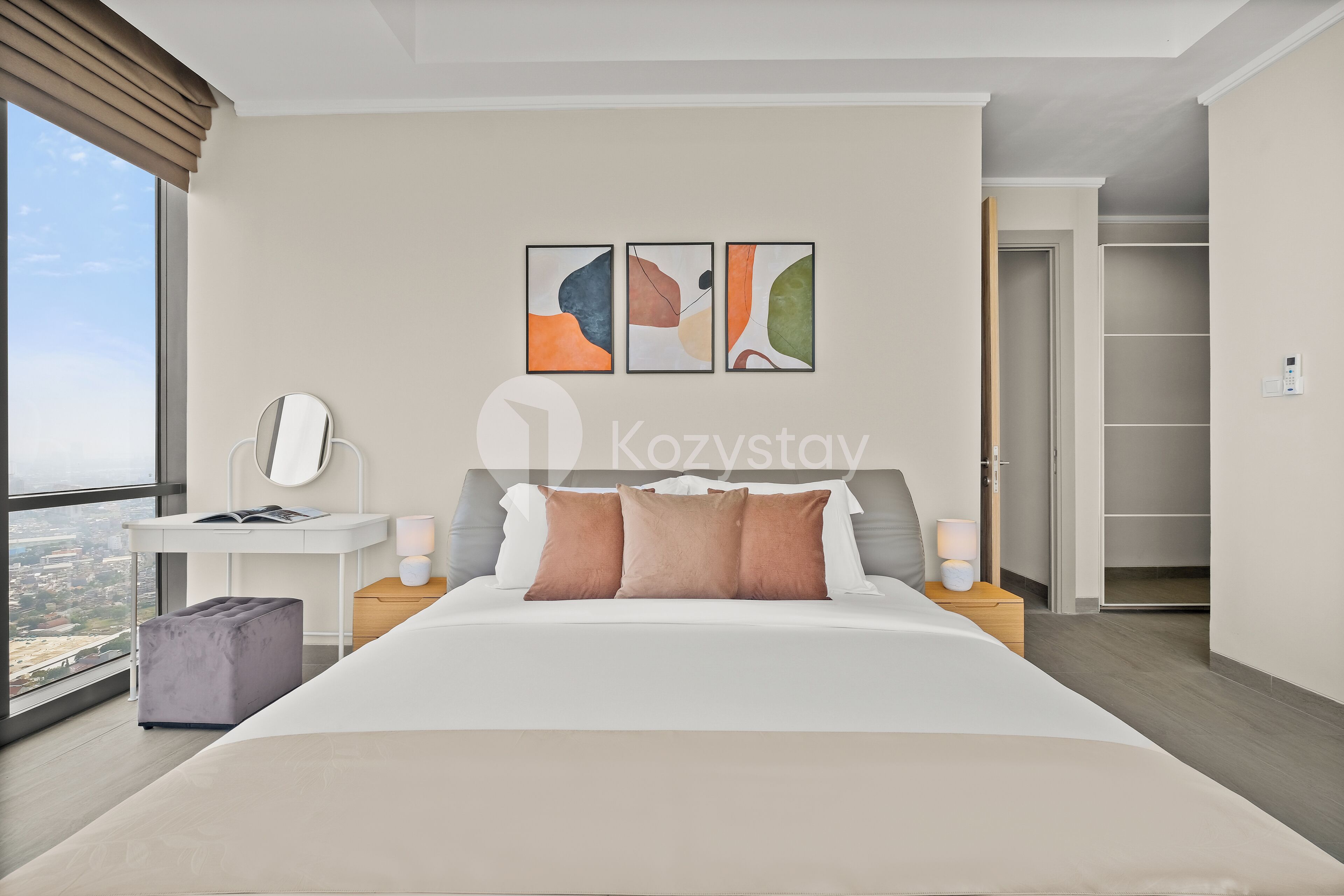 Een moderne hotelkamer met een groot bed, een bureau en uitzicht op de stad.