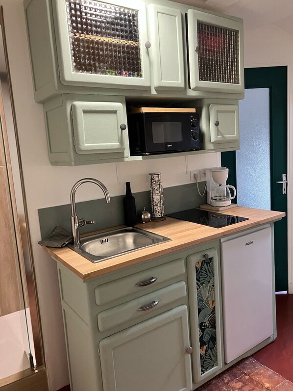 A kitchen with a sink, a microwave, a coffee maker, and a refrigerator. - Studio des tomettes (Blois)