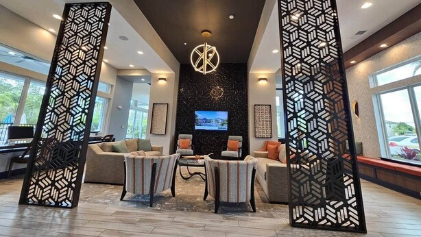 Un espacio moderno con zona de estar, televisor, sofás y una mesa de centro.