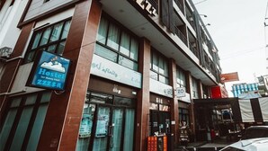A hotel with a modern design, featuring a sign for a hostel and a coffee shop. - Peony's Home (Bangkok)