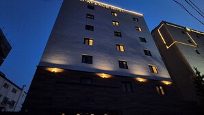 Un hotel de varios pisos con señalización iluminada que dice "Haven Hotel".
