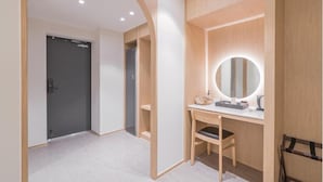 Un baño moderno con tocador, espejo y puerta.