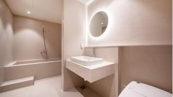 Une salle de bain moderne avec une baignoire sur pieds, un lavabo blanc et un grand miroir.
