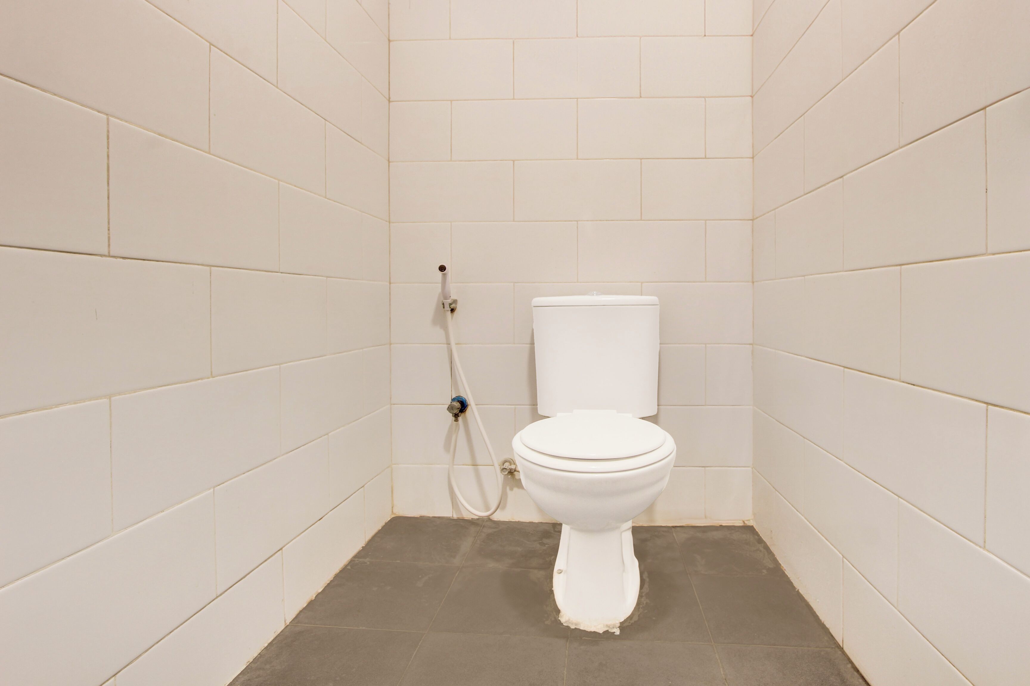 Een kleine badkamer met tegels, een toilet en een douche.