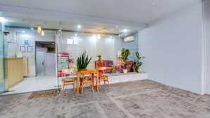 A modern interior with a dining area, seating, and potted plants. - Hotel O Tegal near near Pacific Mall Tegal formerly Hugo Suites Family (Tegal)
