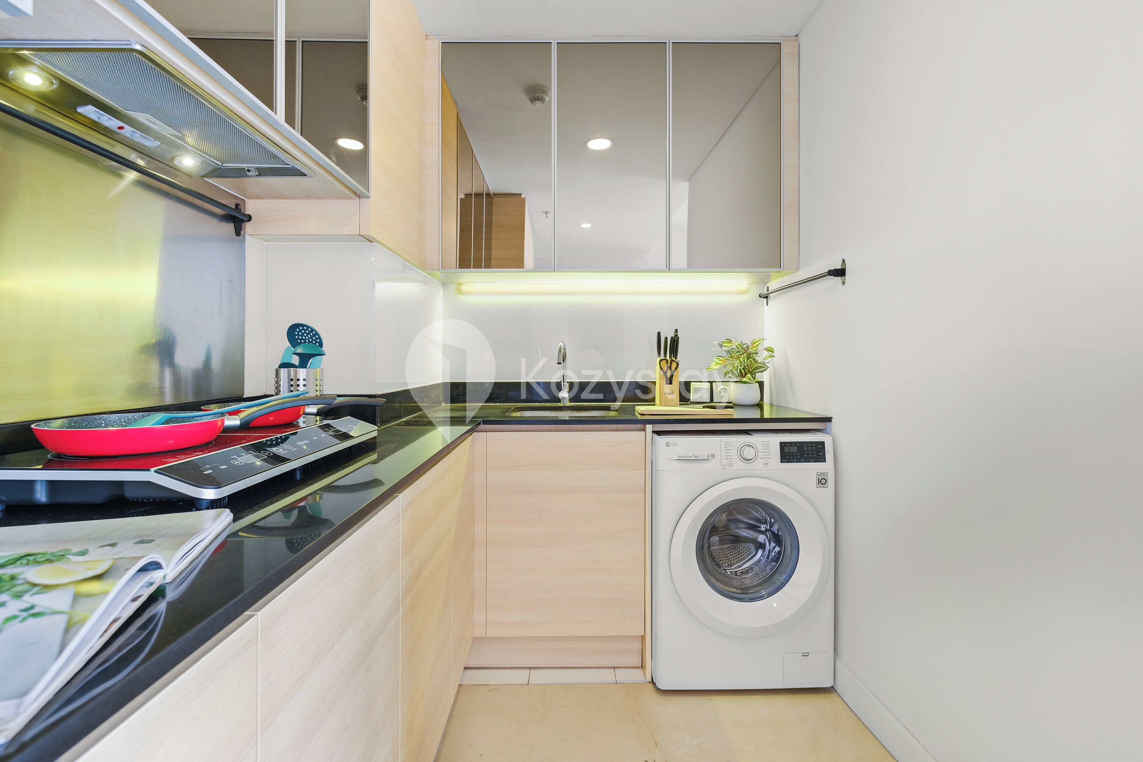 A compact kitchen with a built-in washing machine, a stove, and a microwave.