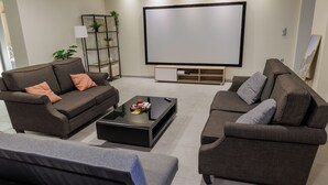Una sala de estar moderna con dos sofás, una mesa de centro, un televisor y una estantería.