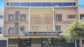 Um edifício moderno com átrio central, amplas janelas e fachada estampada.