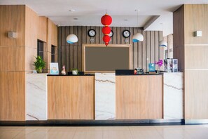 A reception desk with a large mirror, multiple clocks, and a red hanging ornament. - Townhouse Oak Palembang near Palembang Golf Club formerly KR Hotel (Palembang)