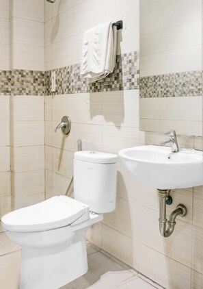 Ein Badezimmer mit Toilette, Waschbecken und Handtuchhalter.