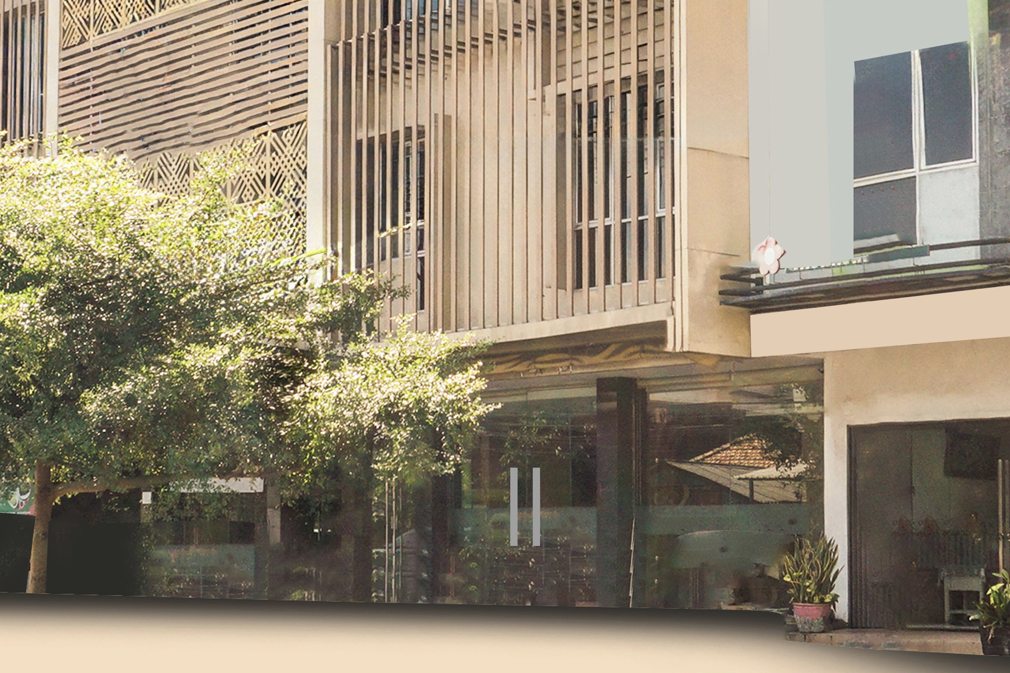 A modern building with a glass facade, vertical wooden slats, and a tree in the foreground.