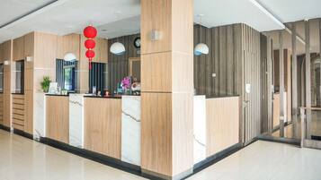 A reception area with a marble counter, wooden paneling, and a clock on the wall.