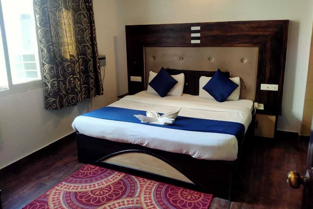 Un letto rifatto con cura, con una coperta bianco e blu, due cuscini blu e un asciugamano decorativo bianco.