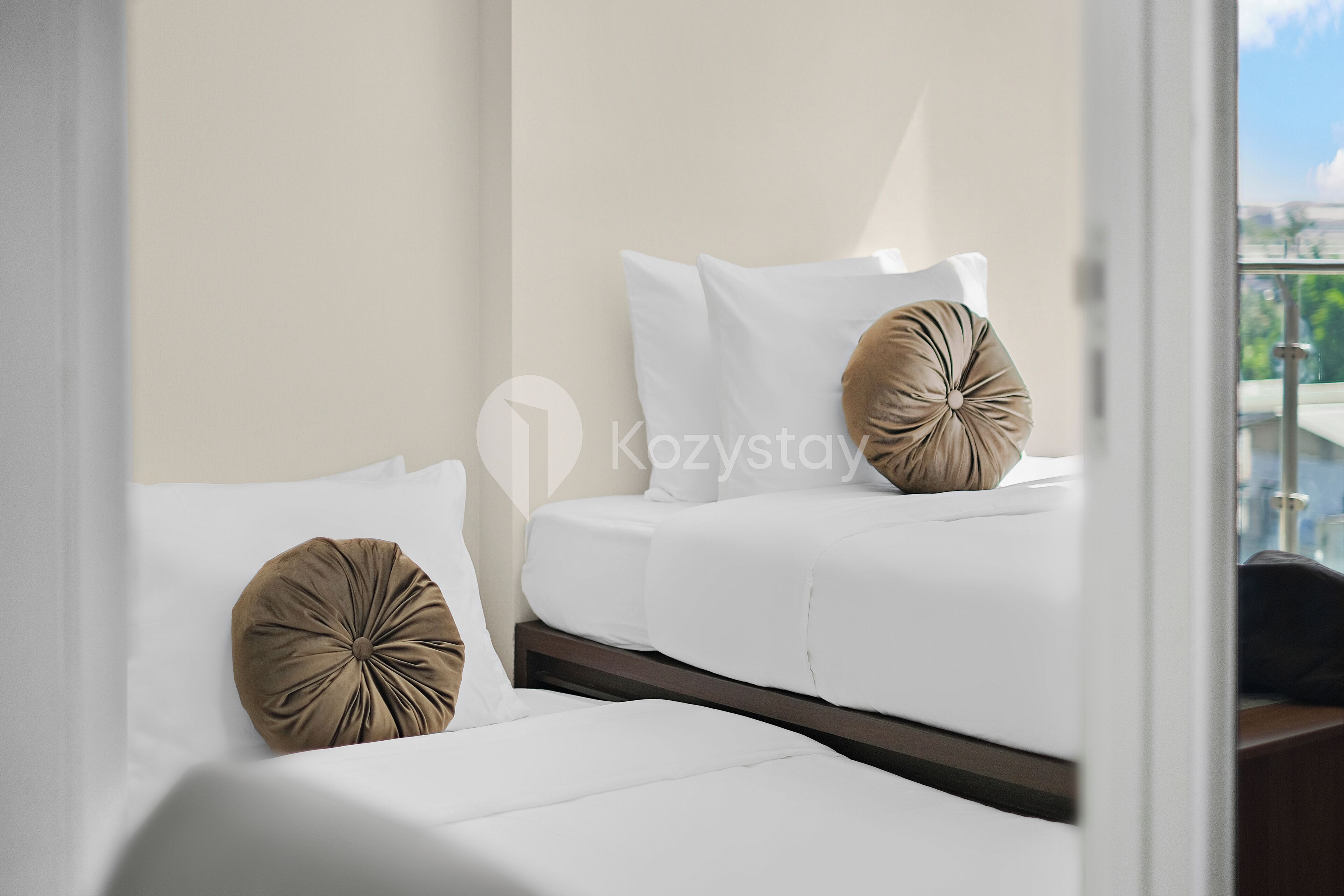 A hotel room with a bed, two pillows, and a nightstand.