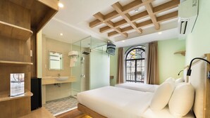 A modern hotel room with a wooden ceiling, a large bed with white bedding, a glass shower enclosure, and a view of the outside through a window with curtains. - Nicecy Hotel - Truong Quyen (Ho Chi Minh City)