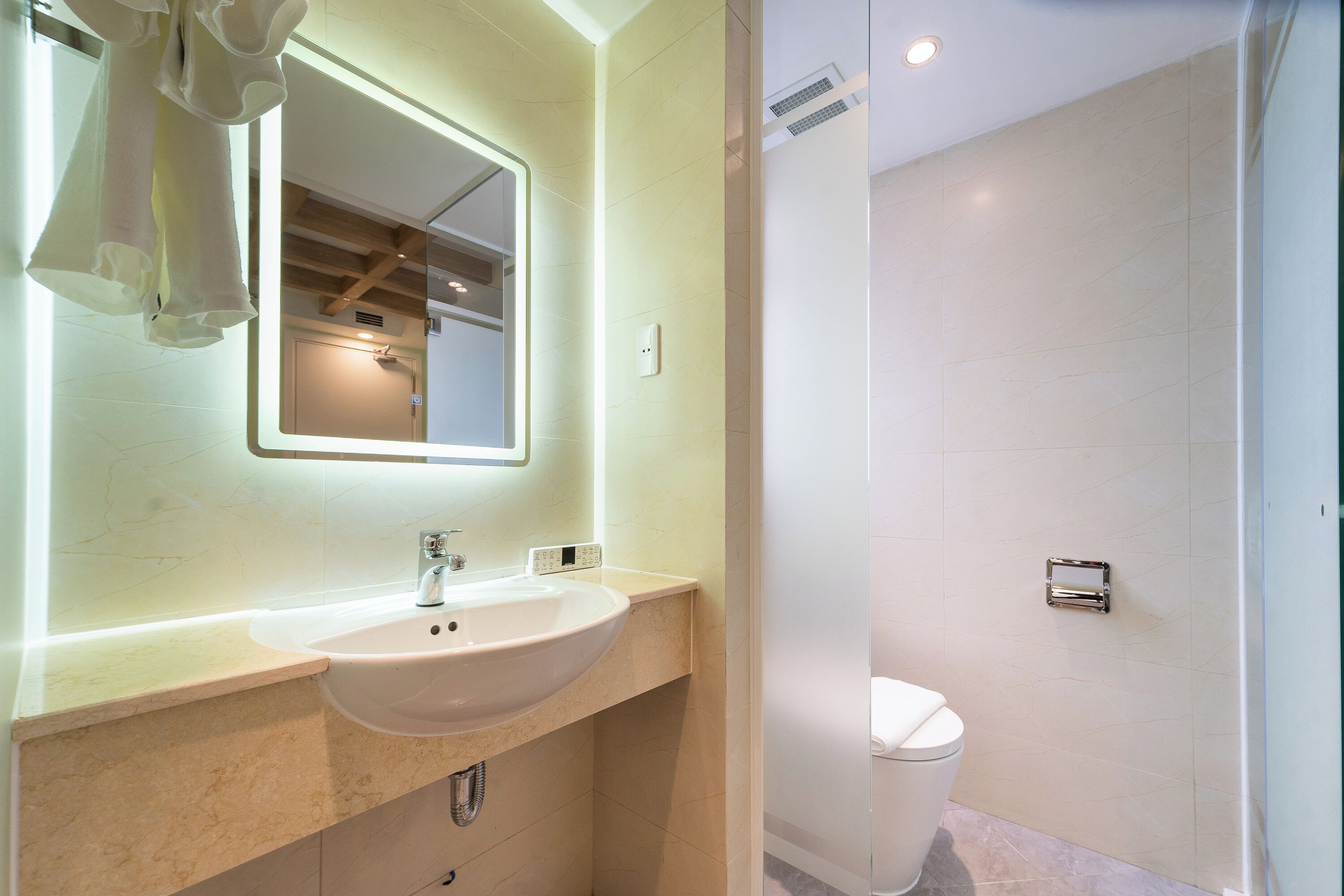 Ein modernes Badezimmer mit Waschbecken, Spiegel und Toilette.