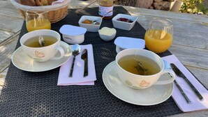 A breakfast setup with croissants, honey, jam, butter, and orange juice on an outdoor table. - Bed and breakfast in southern Corsica near dream beaches (Sotta)