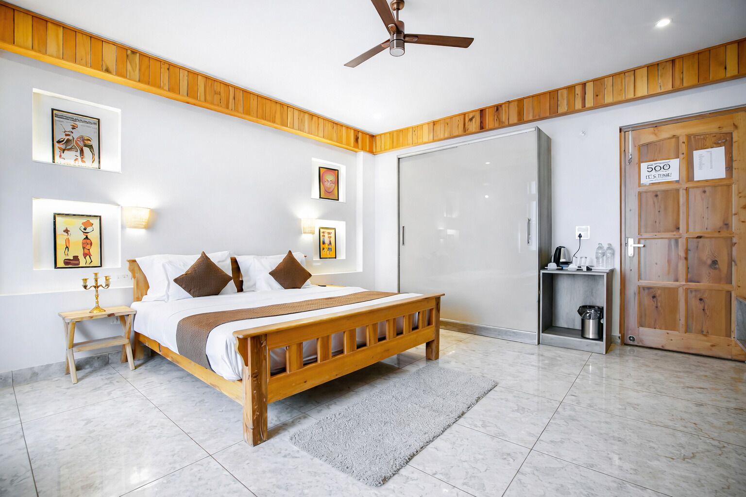 A bedroom with a wooden bed, a ceiling fan, and a wardrobe with a sliding door.