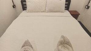 A bed with a white mattress and two folded towels placed on it. - Funkymonkey Cafe&hostel (Vientiane)