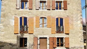 A stone building with multiple windows, some with shutters, and a central door. - C'est dans notre Cocoon face au coeur du Village de formiguere. (Formiguere)