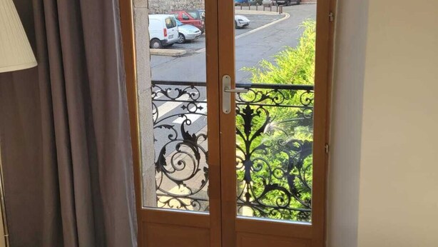 A room with a bed, a lamp, and a view through a door with a balcony. - C'est dans notre Cocoon face au coeur du Village de formiguere. (Formiguere)