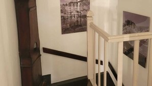 A staircase with a wooden handrail, a dark wooden floor, and a wall-mounted light fixture. - C'est dans notre Cocoon face au coeur du Village de formiguere. (Formiguere)