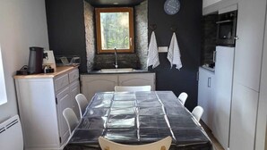 A compact kitchen with a dining table, chairs, a sink, and a window. - C'est dans notre Cocoon face au coeur du Village de formiguere. (Formiguere)