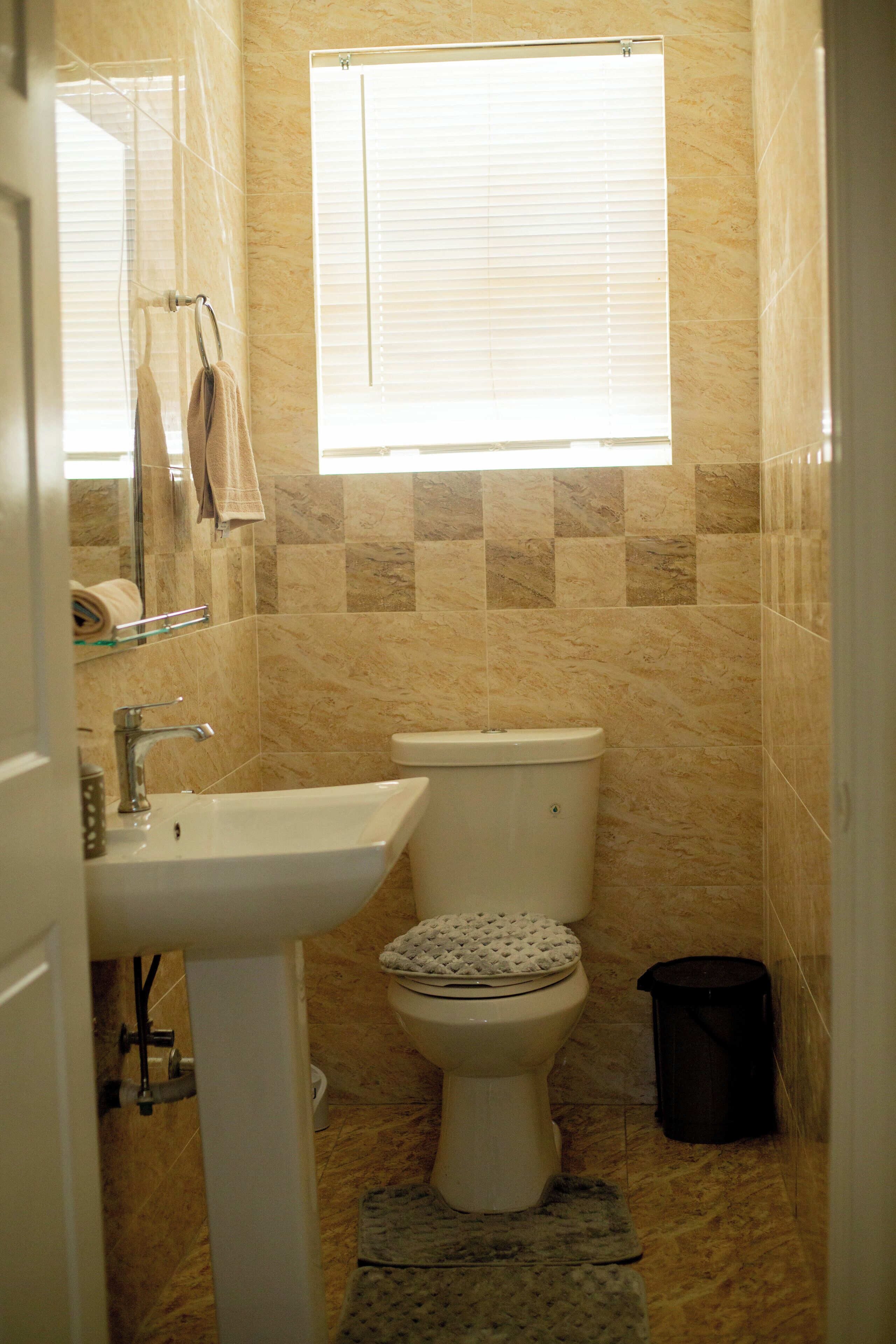 A bathroom with a sink, toilet, and window.