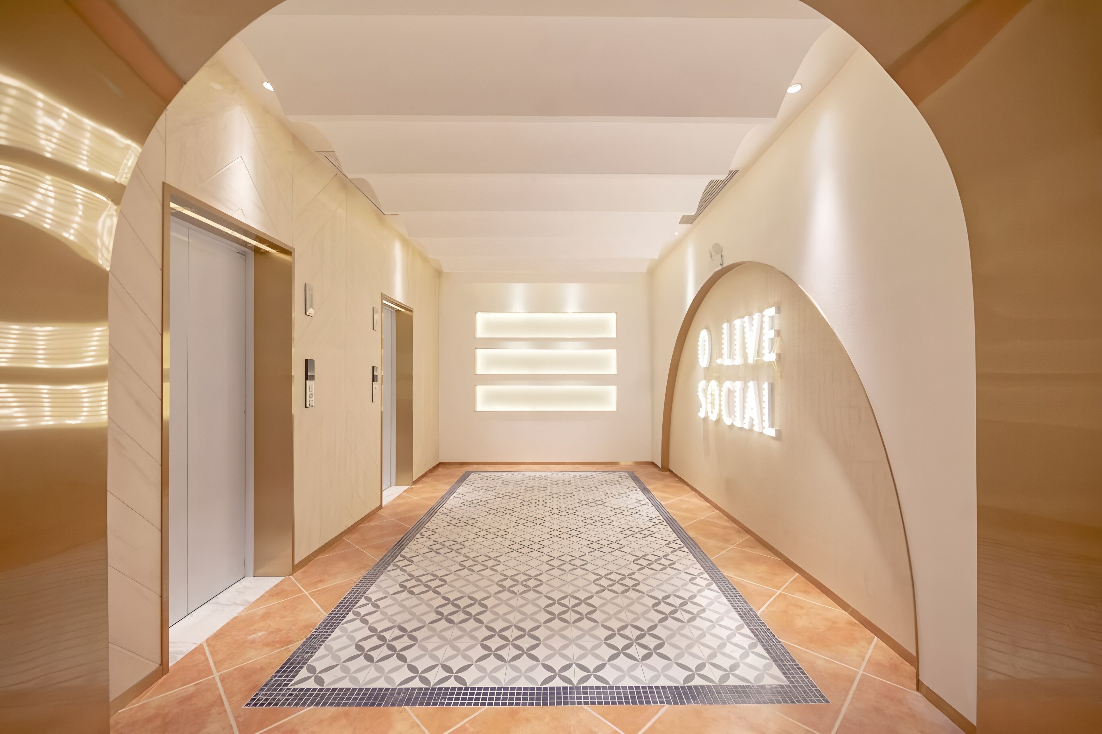 A hallway with a patterned rug, a reception area with a 'Welcome' sign, and an elevator.