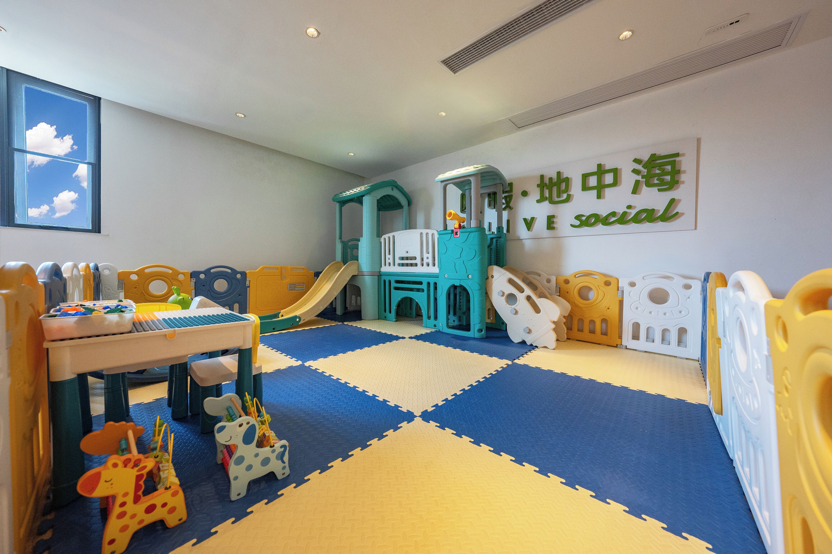 A children's play area with a slide, play structures, and a play table.