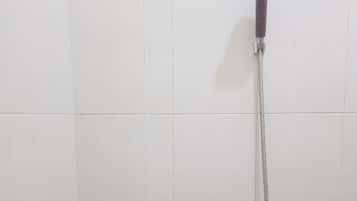 Chuveiro com chuveiro manual e mangueira flexível.