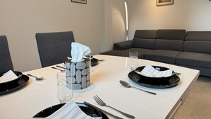 Een eettafel gedekt met borden, bestek, glazen en een zakdoos.