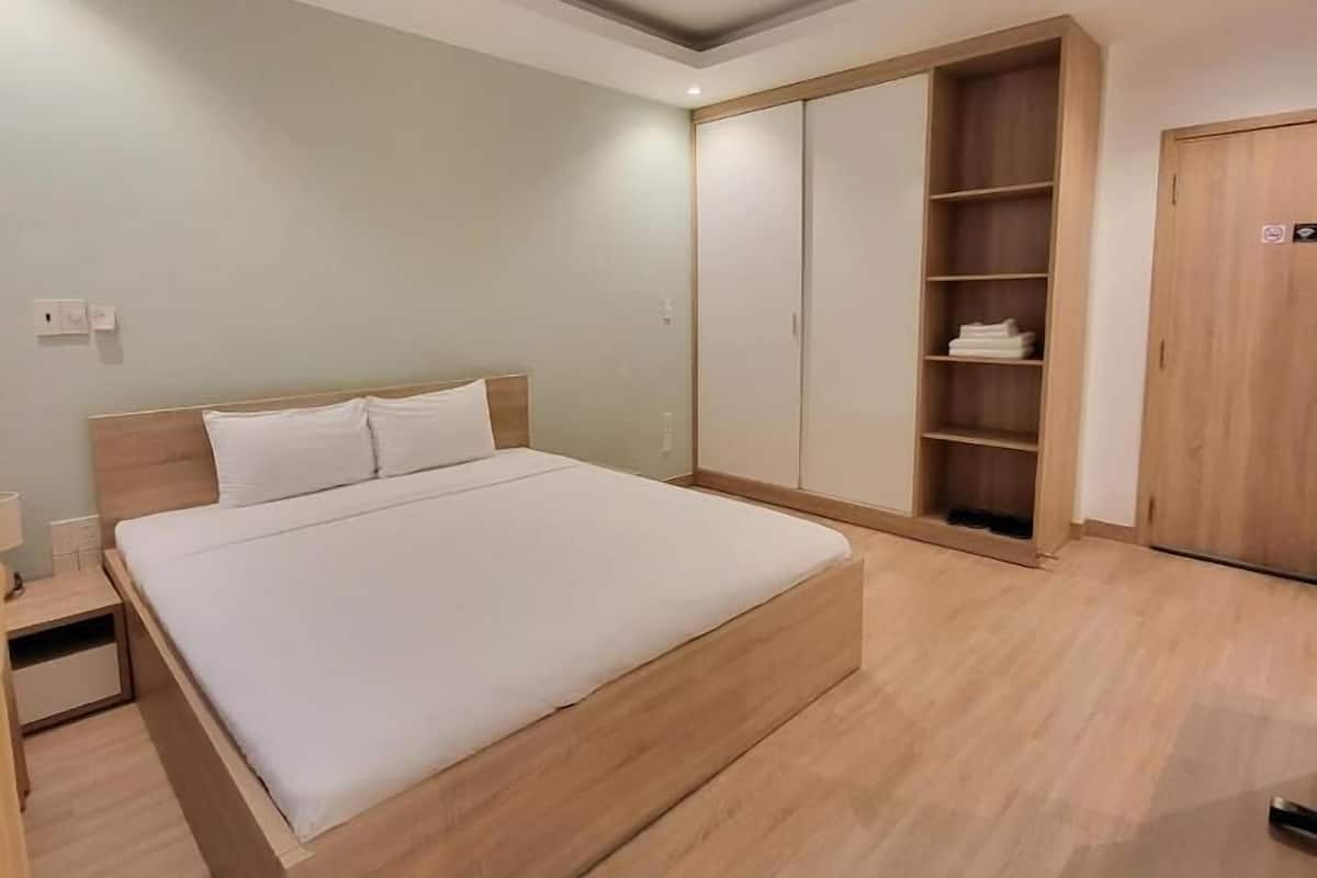 Ein Schlafzimmer mit einem großen Bett, einem Holzschrank und Einbauschränken.