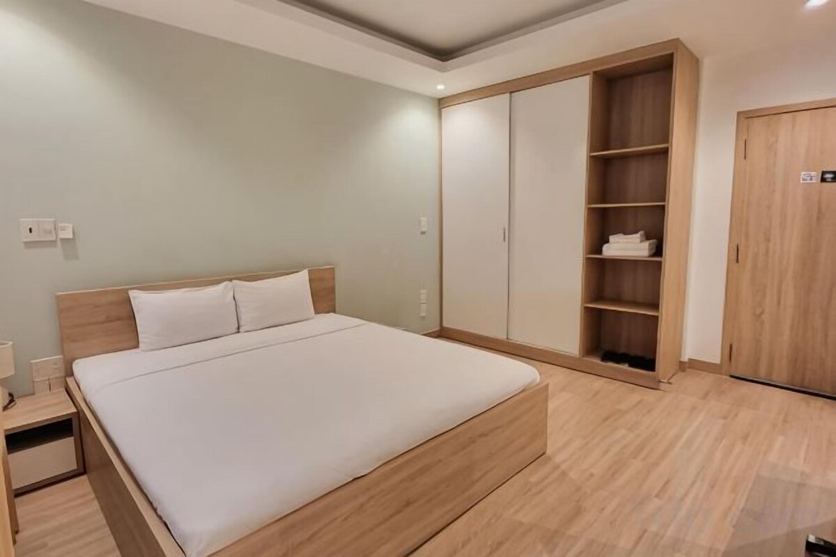 A bedroom with a bed, a wardrobe, and a nightstand.