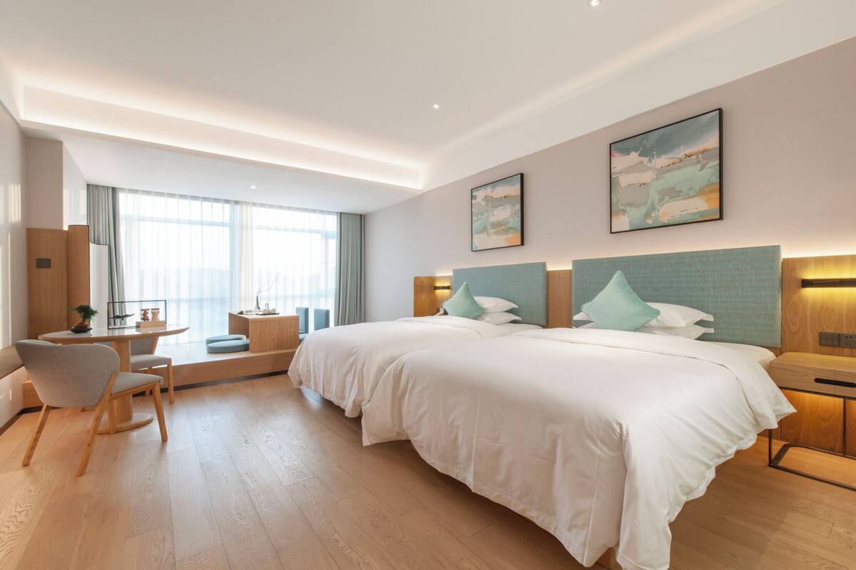 Una habitación de hotel moderna con una cama grande, un escritorio y una silla.