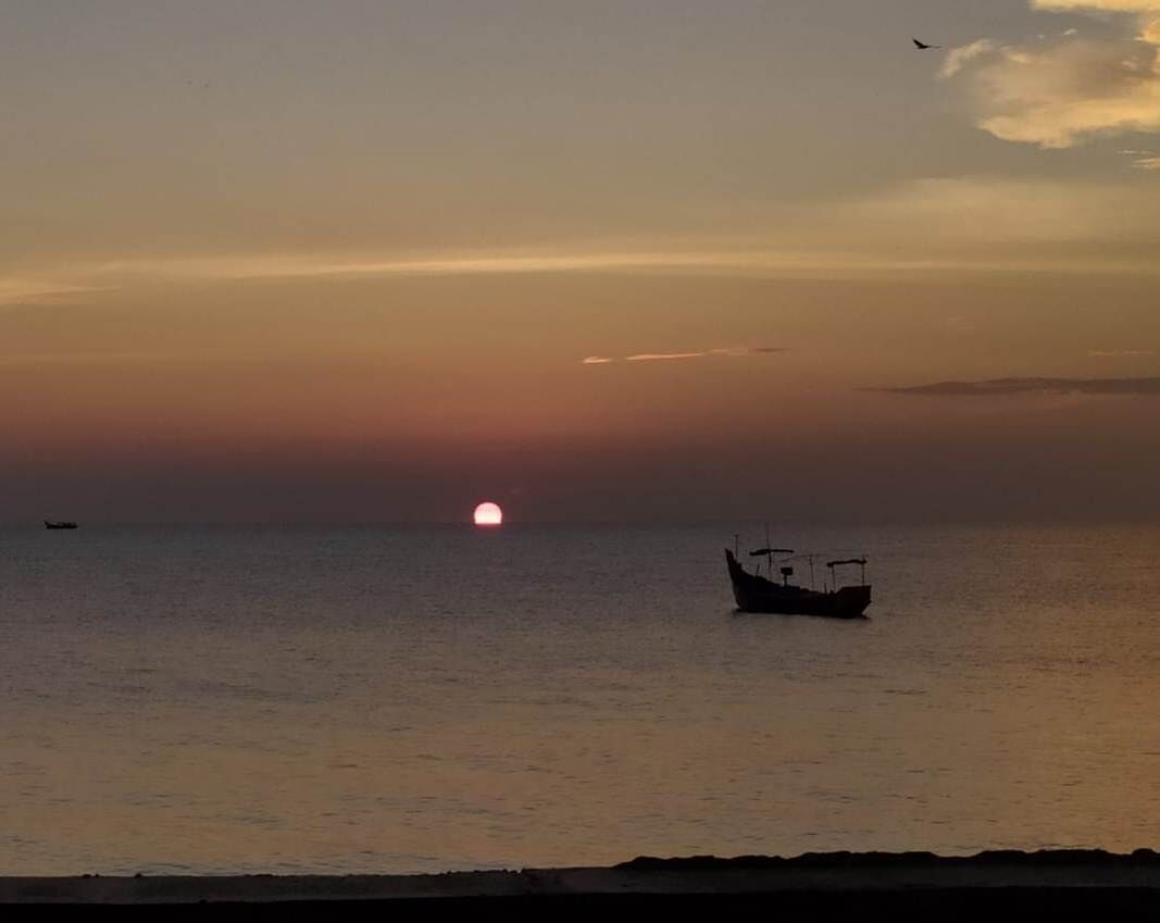 A boat on calm water during sunset.