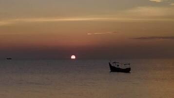 A boat on calm water during sunset.