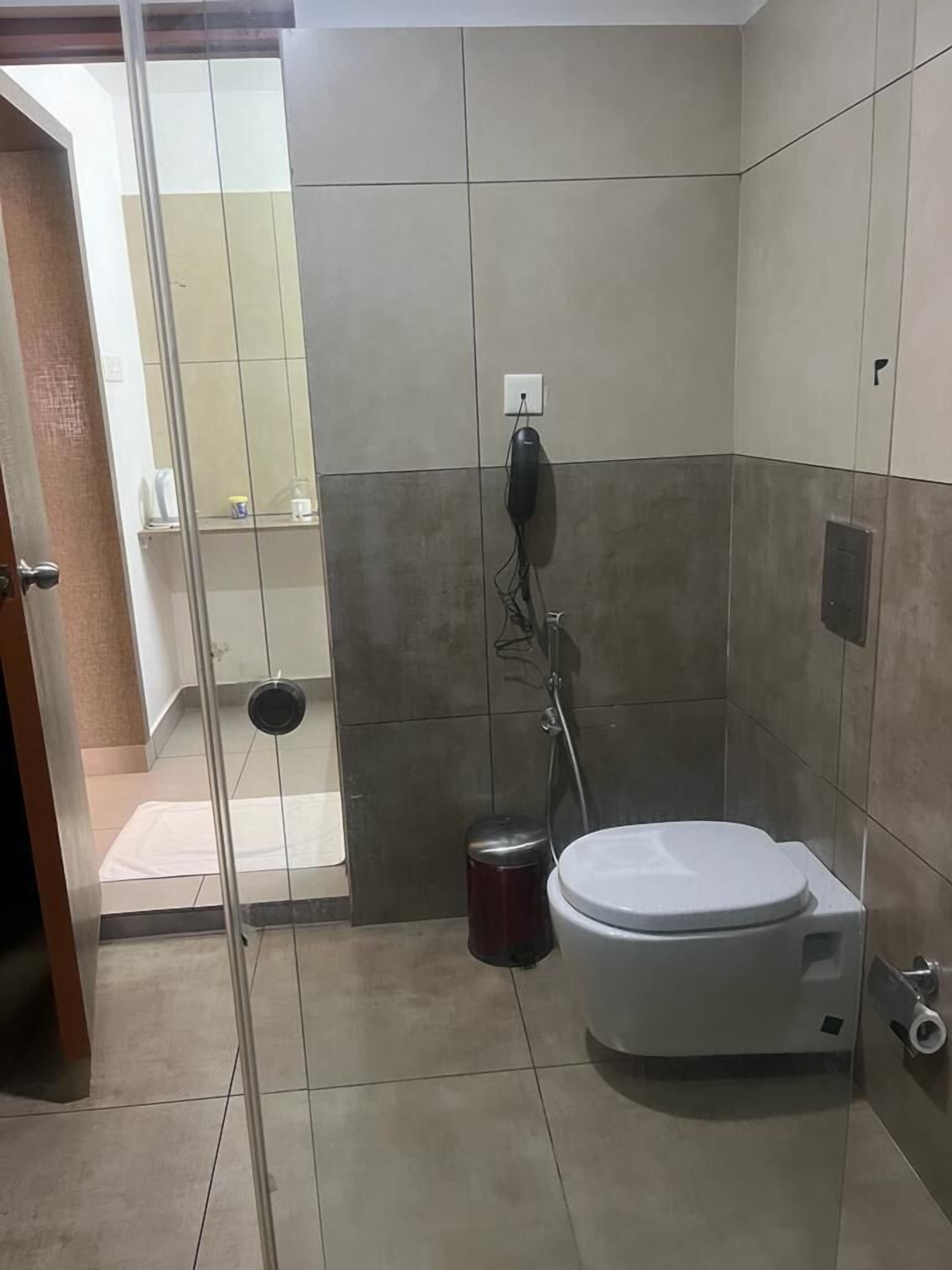 A bathroom with a toilet, a bidet, and a trash bin.