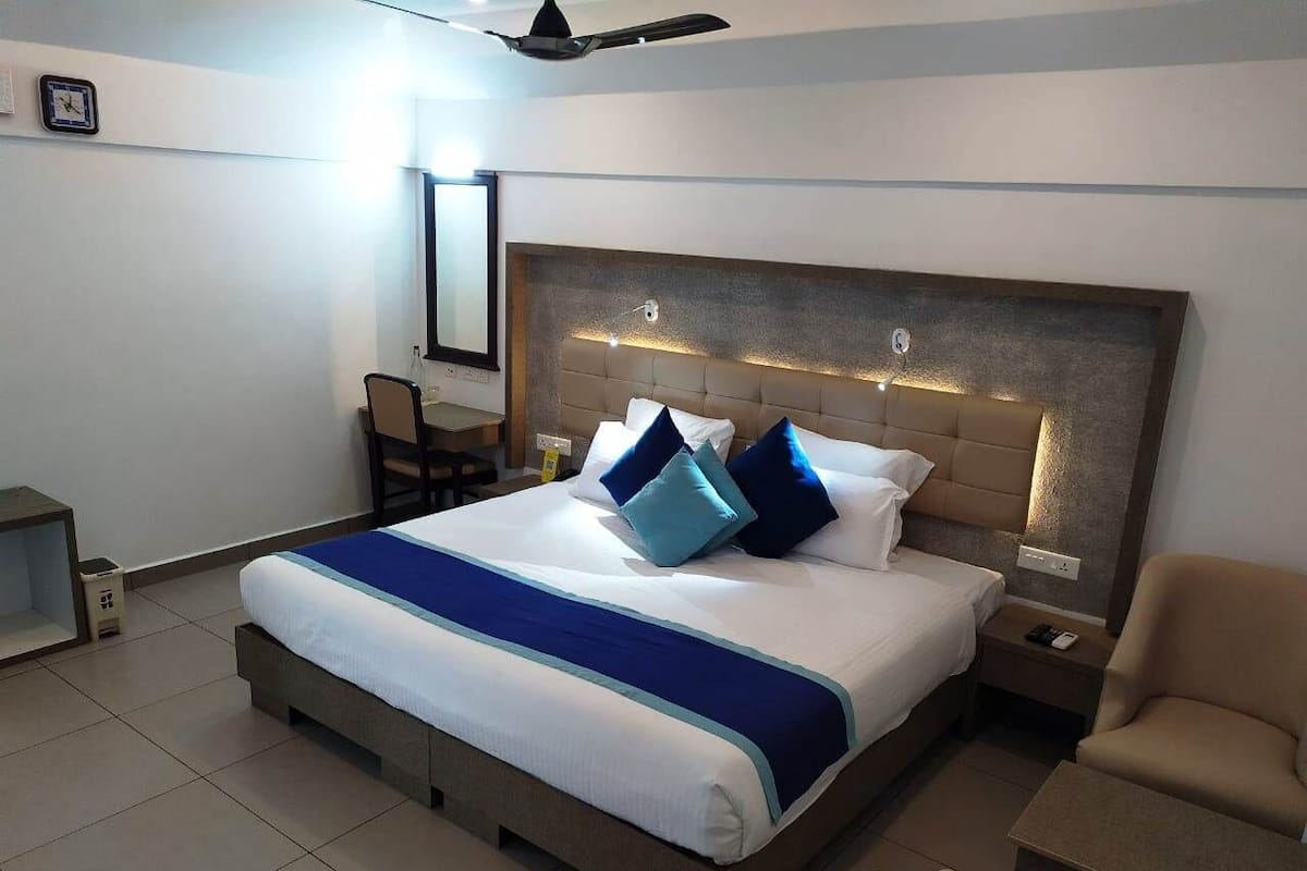 Ein Hotelzimmer mit einem großen Bett, einem Schreibtisch und einem Stuhl.