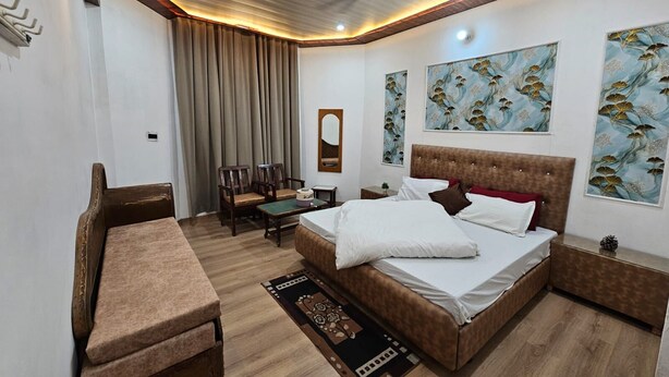 Une chambre d’hôtel avec un lit, un canapé, une petite table et un miroir.