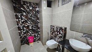 Une salle de bain équipée de toilettes, d’un bidet et d’un lavabo.