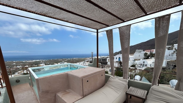 A balcony with a view of the sea and white buildings, a small pool, and a beige sofa. - Villa Pasithea, Oia, Santorini (Santorini)