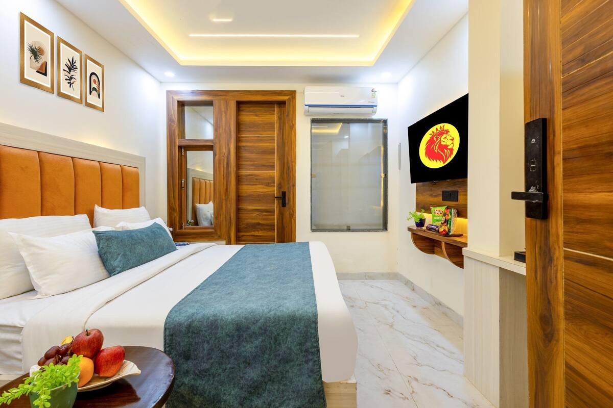 Ein Hotelzimmer mit einem Bett, einem Fernseher, einer Holztür und einer Wand-Klimaanlage.