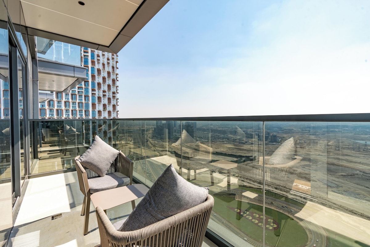 Ein moderner Balkon mit Korbmöbeln und Glasbrüstung, der einen Blick auf die Stadt bietet.