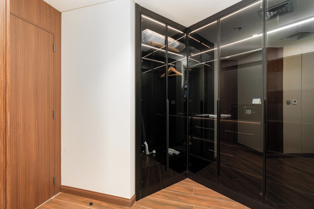 Ein moderner Kleiderschrank mit Schiebetüren, ein Holzschrank und ein gefliester Boden.