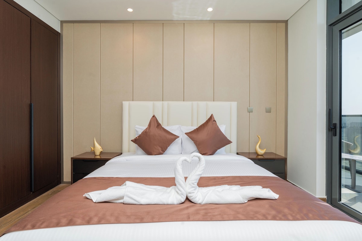 Ein Hotelzimmer mit einem Bett, zwei Nachttischen, einem Kleiderschrank und Blick durch eine Glastür.