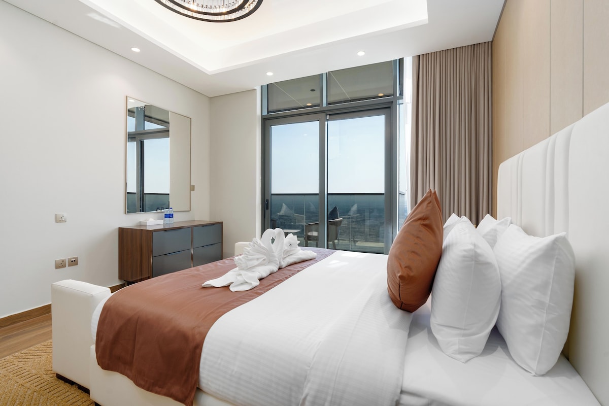 Ein Hotelzimmer mit einem großen Bett, einem Nachttisch, einem Spiegel, einem Fenster mit Blick und einer Deckenleuchte.